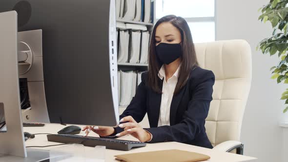 Female Corporate Manager in Face Mask at Work