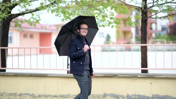 Young Man Walking Through Rainy Weather