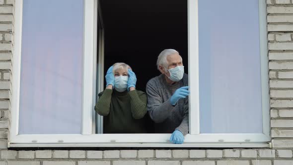 Old Grandparents Stay at Window Isolated at Home on Quarantine. Coronavirus