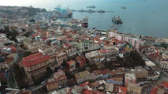 Aerial orbit of Cerro Concepcion colorful houses and Lutheran Church, Valparaiso city and Sea Port i