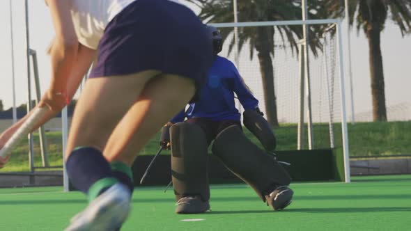 Female hockey players playing on the field