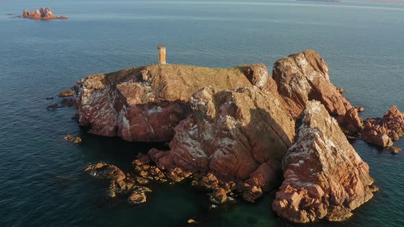 An Abandoned Lighthouse on Top of a Rocky Island at Sunrise