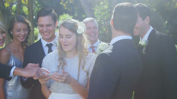 Happy bride, groom and family checking photographs 4K 4k