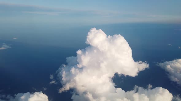 Beautiful Aerial View at Land and White Fluffy Clouds Through Window of Flying Plane