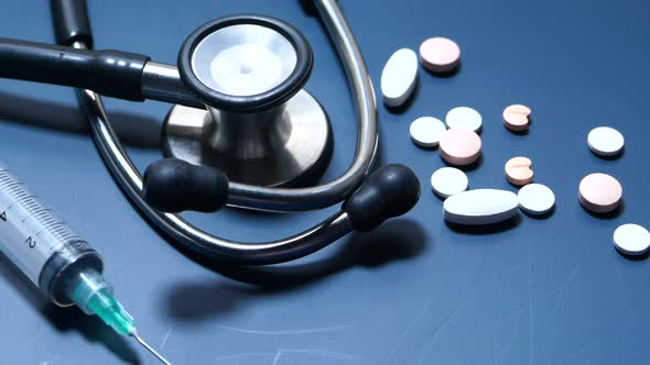 Close Up of Pills, Syringe and Stethoscope on Color Background 