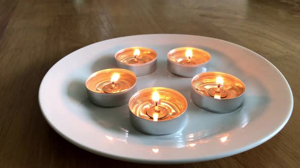 Candles on a plate with dancing flames