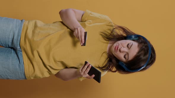 Woman Holding Smartphone Typing Credit Card Details Doing Online Shopping While Listening to Music