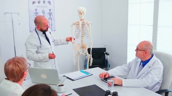 Expert Doctor in Radiology Pointing at Human Skeleton