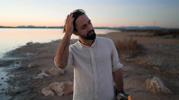 Spanish Hipster Man with Guitar Walking By the Torrevieja Pink Lake at Sunset Alicante