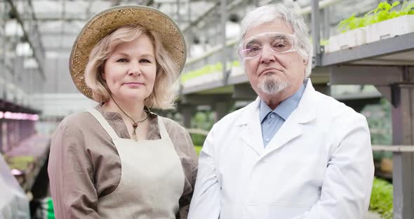 Portrait of Senior Caucasian Woman in Straw Hat and Man in Protective Eyeglasses Looking at Camera