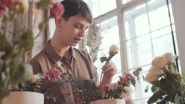 Young Woman Making Floral Composition in Hatbox in Flower Shop