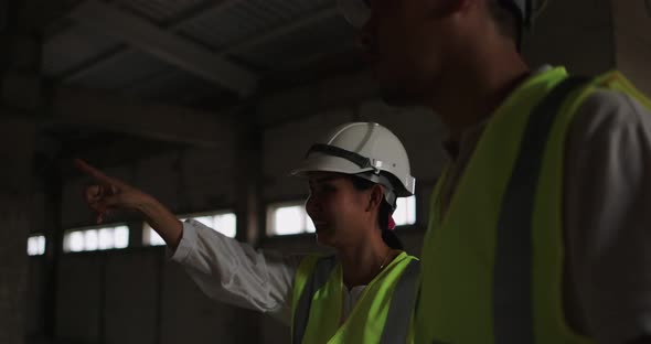 Industrial Engineers In Hard Hat Wearing Safety Jacket Working In The Building Site.