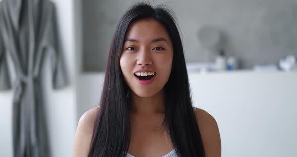 Amazed Asian Woman Looking at Camera and Saying WOW in Bathtub