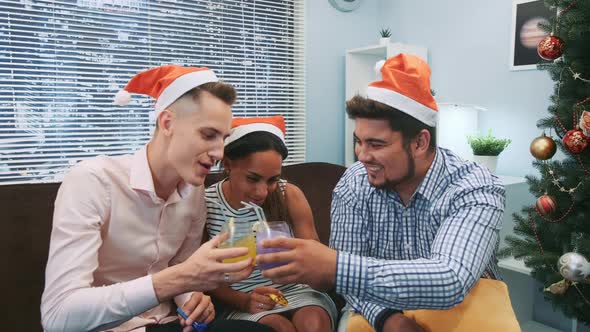 Close Up of Two Boys and a Girl in Santa Hats Making Cheers and Blowing Party Whistles