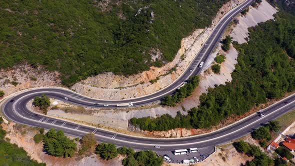 Panorama of Green Wooded Mountains with Winding Serpentine Road From Above