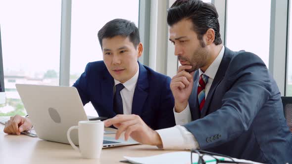 Two Business People Talk Project Strategy at Office