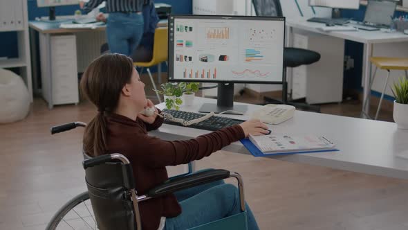 Busy Paralysed Handicapped Woman Worker Talking at Phone with Colleague