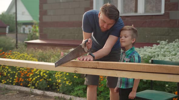 Male Carpenter with His Son Working Outside Near the House