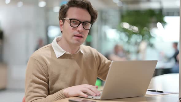 Man with Laptop Showing Thumbs Up Sign