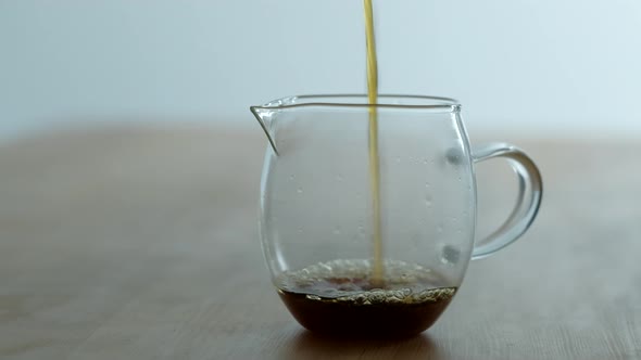 Barista Pours Fresh Brewed Coffee Into a Transparent Mug
