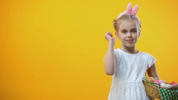 Happy Easter Text, Cute Child With Eggs Basket in Bunny Ears Showing Thumbs Up