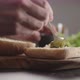 Man Spreading Pesto on Small Ciabatta Bun for Sandwich on Kitchen Countertop - VideoHive Item for Sale