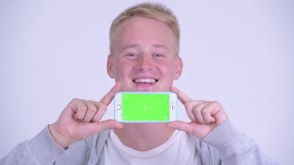 Face of Happy Young Blonde Handsome Man Showing Phone