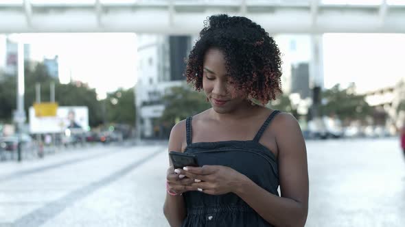 Cheerful African American Woman Texting on Smartphone