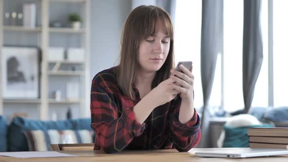 Casual Young Girl Using Phone for Online Messaging