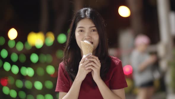 Asian young woman travel in Bangkok, Thailand, happy walking and eat ice cream at The Khao San Road.