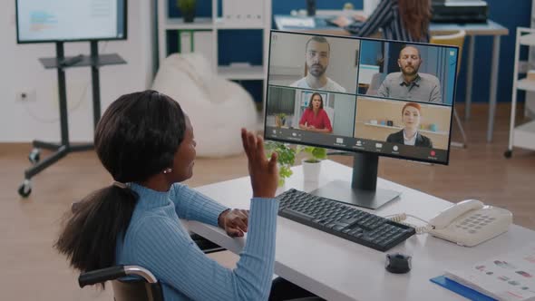 Handicapped African Manager Woman Discussing with Remote Colleagues