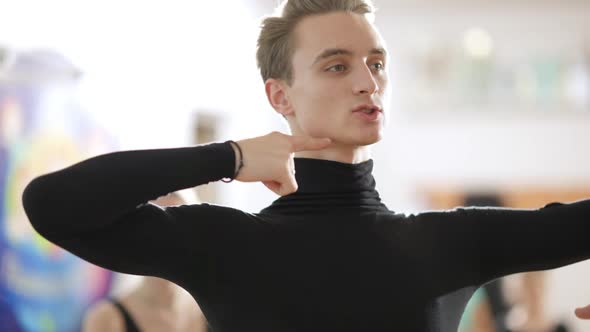 Closeup Portrait of Handsome Young Ballet Teacher Talking Standing in Dance Studio in Backlight