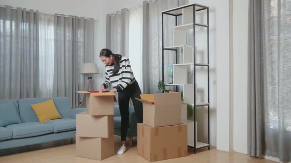 Asian Woman Moving Into A New House Taking Stuff Out And Decorating The Habitat Bookcase