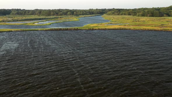 descending crane shot over the waters at East Islip Marina & Park focusing on the marsh area with a