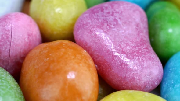 Pile of Many Round Chewy Candies Dragee in Multicolored Glaze Rotate Slowly on Turntable