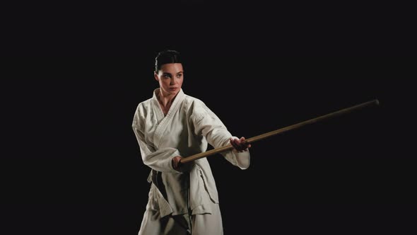 Young Woman in Kimono Practicing with Jodo