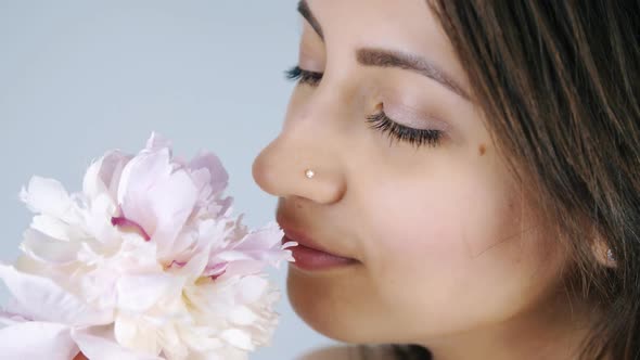 Young Woman Sniffing Pink Flower