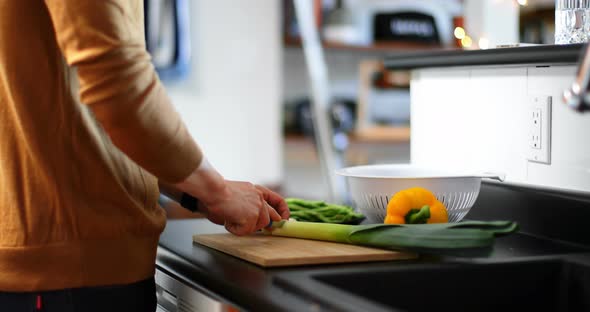 Man making slices of green leafy vegetable 