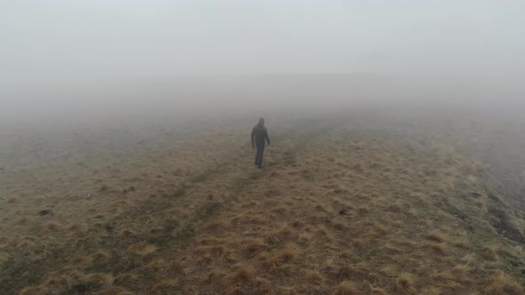 Tourist Traveler Man in Tourist Clothes Walks Along the Top of a Plateau Next to a Deep Cliff Along