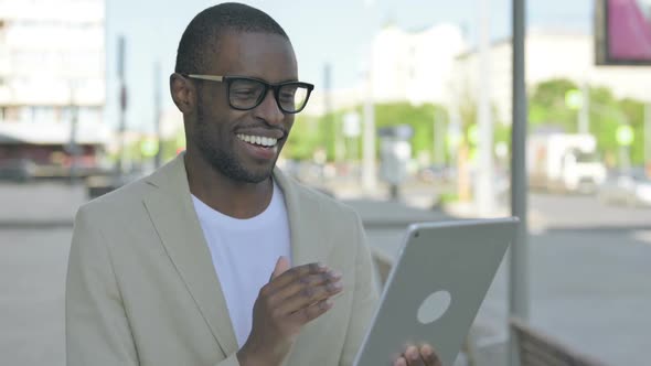 Video Call on Tablet By African Man Outdoor