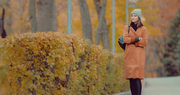 Beautiful Young Brunette Girl Walking in the Park in Autumn