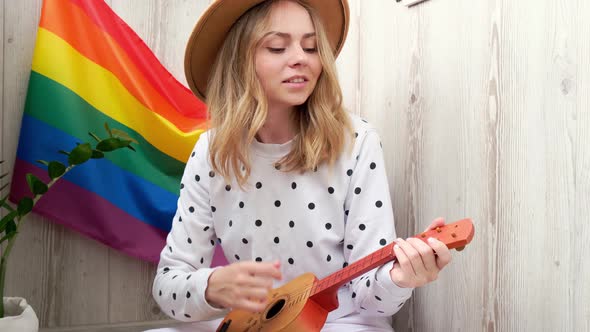 Young Millennial Hippie Woman Sitting on Balcony Play Guitar