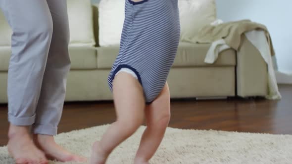 Toddler Taking First Steps with Support alt