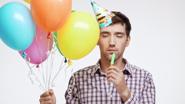 Crushed Young Caucasian Male with Dark Hair and Light Bristle on White Background Wearing Birthday