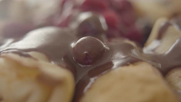 Camera Moving Along Baked Pancakes with Chocolate Syrup and Raspberries on the Top. Close-up of