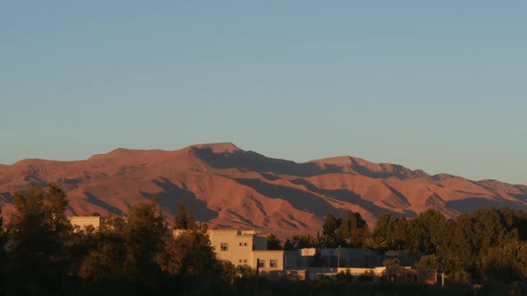 Time lapse of changing light conditions on distant mountains during sunset in a desert.