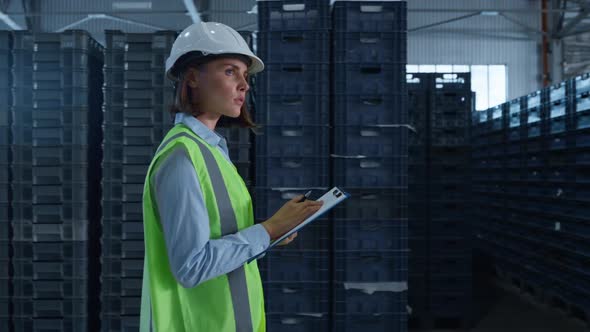 Woman Storehouse Employee Noting Shipment Details Examining Factory Warehouse