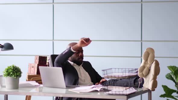 Closeup Image of an AfricanAmerican Businessman While Feet Up on the Desk