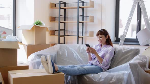 Asian Woman with Smartphone Moving Into New Home