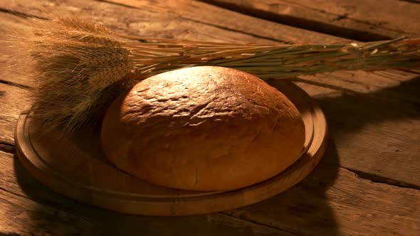 Loaf of Round Yellow Bread and Wheat Ears